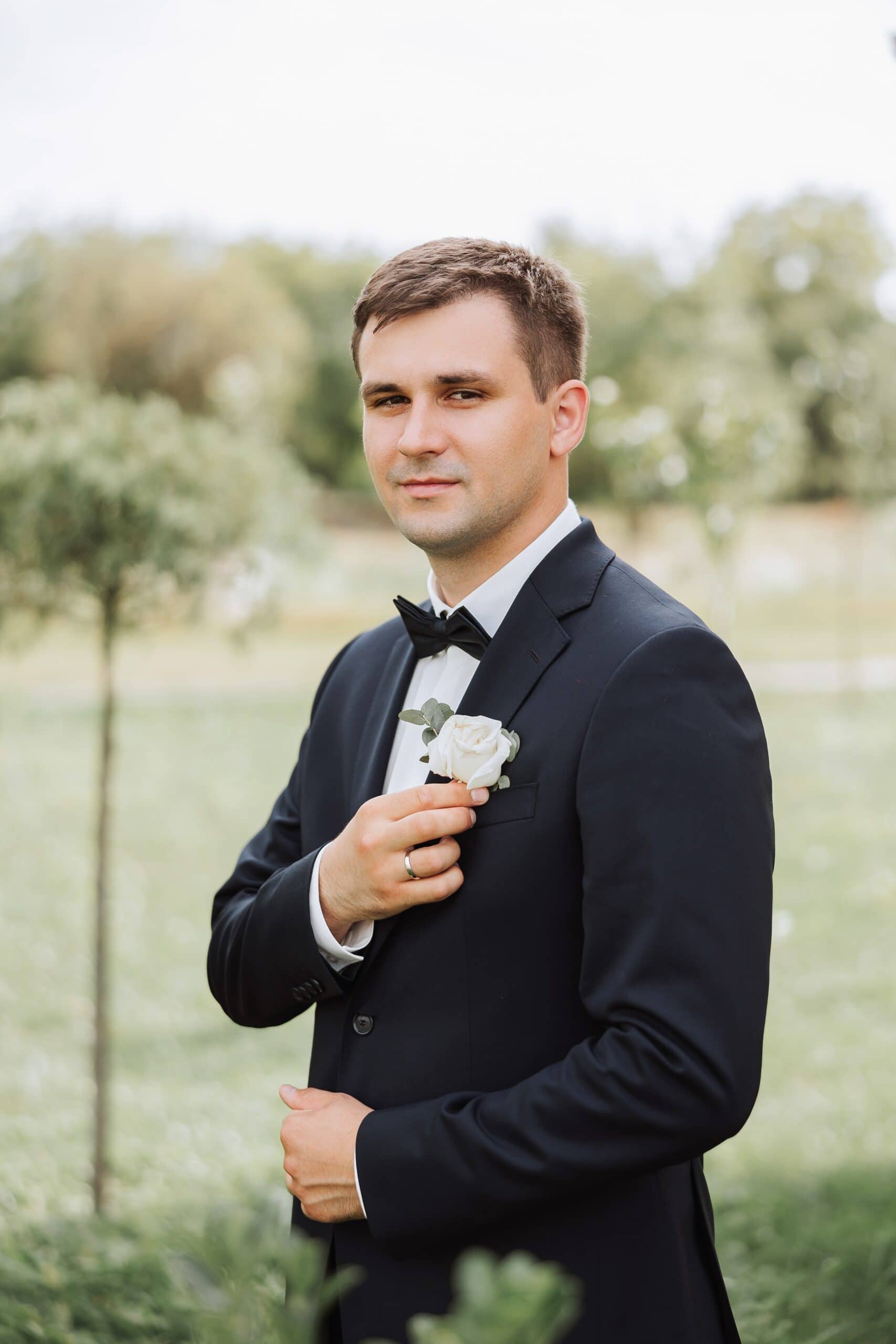 a groom in his black suit rental